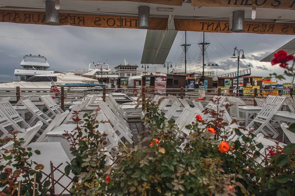 PAPHOS, ZYPERN - 31. MÄRZ 2020: grüne Pflanzen, Tische und Stühle auf der Terrasse in der Nähe des Yachtclubs — Stockfoto