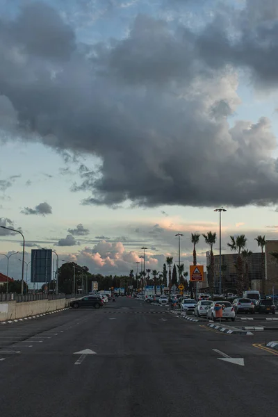 PAPHOS, CHIPRE - Março 31, 2020: estacionamento com carros modernos perto de construção e palmeiras — Fotografia de Stock