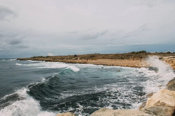 Salpicaduras de agua forman mar mediterráneo cerca de la costa - foto de stock
