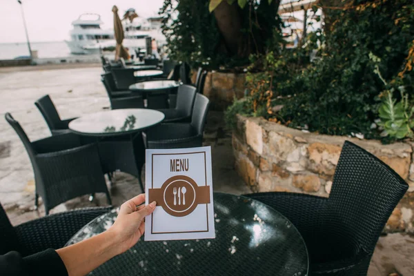 Cropped view of woman holding menu in restaurant — Stock Photo