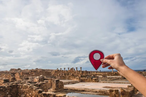 Cropped view of woman holding paper as location sign near ancient House of Theseus — Stock Photo