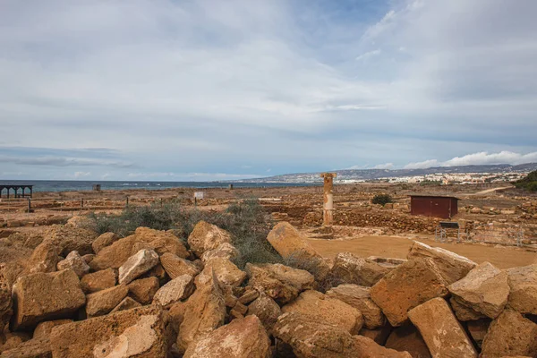 Hierba verde cerca de rocas contra el cielo azul con nubes - foto de stock