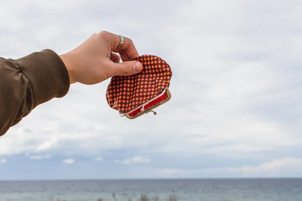 Обрізаний вид людини, що тримає порожній гаманець біля моря — стокове фото