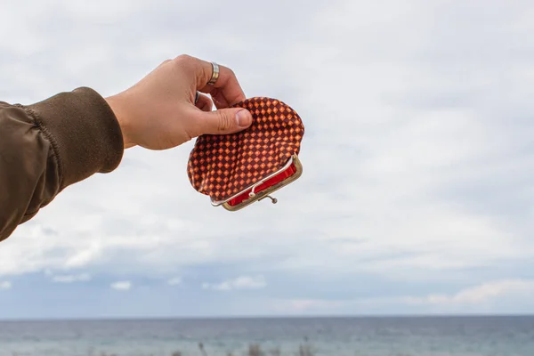 Vista recortada del hombre sosteniendo la cartera vacía cerca del mar - foto de stock