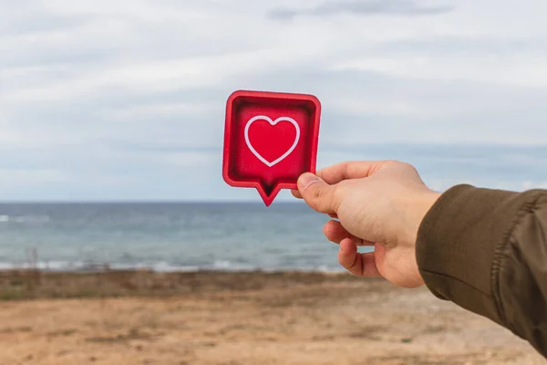 Man holding paper heart near mediterranean sea — Stock Photo