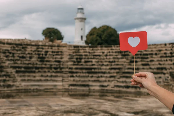 Vue recadrée de femme tenant comme sur le bâton près de l'amphithéâtre et du phare — Photo de stock