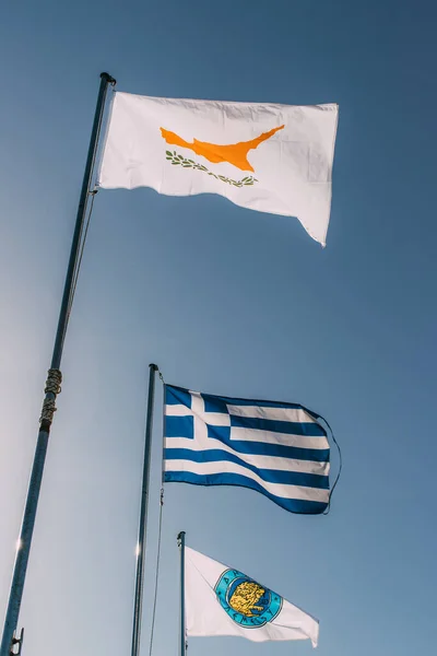 Low angle view of national flags of greece and cypus against blue sky — Stock Photo