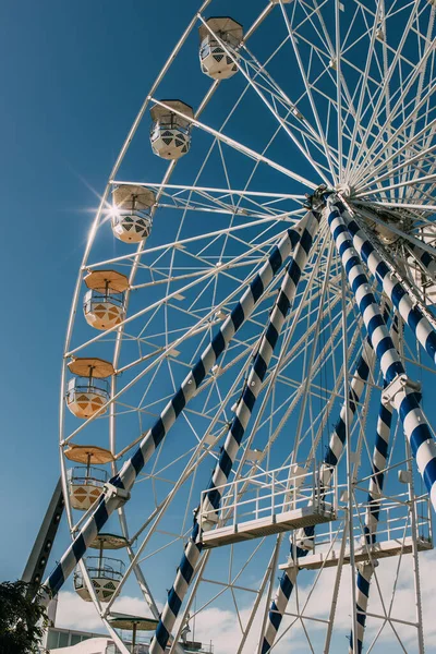 Низкоугольный вид металлического колеса обозрения на голубое небо — стоковое фото