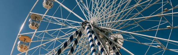 Панорамный снимок колеса обозрения на фоне голубого неба — стоковое фото