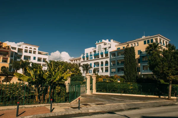 Árboles verdes cerca de casas modernas contra el cielo azul - foto de stock