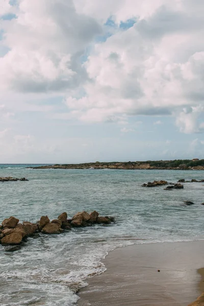 Bahía con rocas cerca del mar Mediterráneo contra el cielo azul con nubes - foto de stock