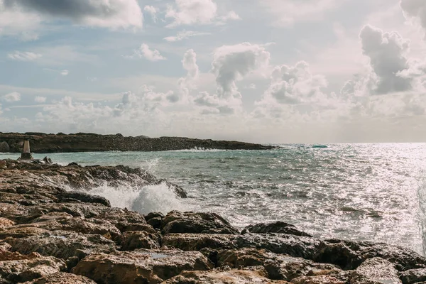 Pietre bagnate vicino al Mar Mediterraneo contro il cielo blu con nuvole — Foto stock