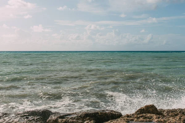 Rocce bagnate vicino al Mar Mediterraneo contro il cielo blu con le nuvole — Foto stock