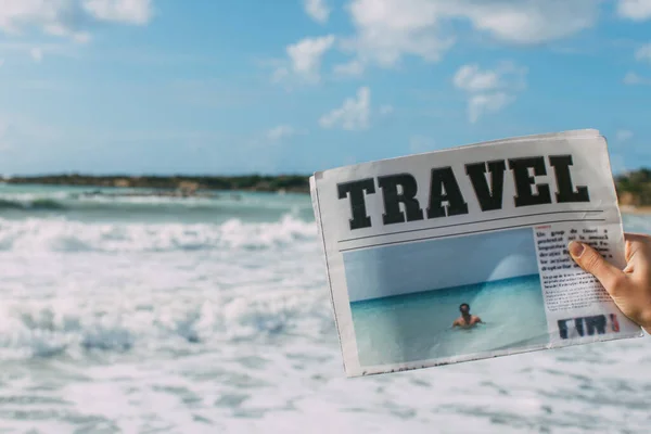 Abgeschnittene Ansicht einer Frau, die eine Reisezeitung in der Nähe des Meeres hält — Stockfoto