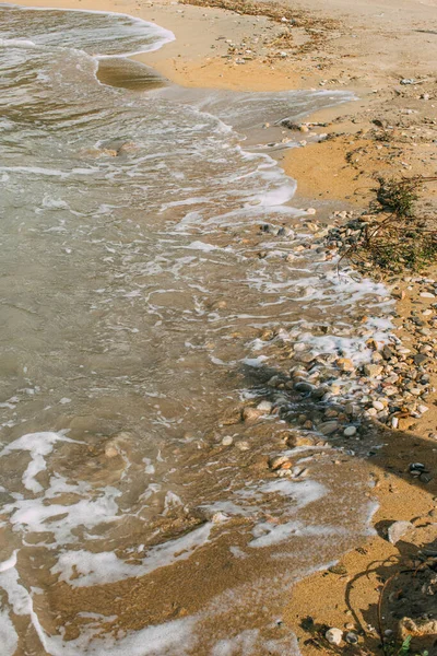 Ombre su spiaggia sabbiosa con pietre vicino al mare — Foto stock