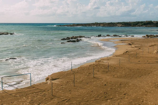 Playa de arena húmeda cerca del mar Mediterráneo contra el cielo azul - foto de stock