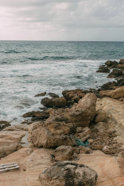 Ruhige Küste mit Steinen am Mittelmeer gegen wolkenverhangenen Himmel — Stockfoto