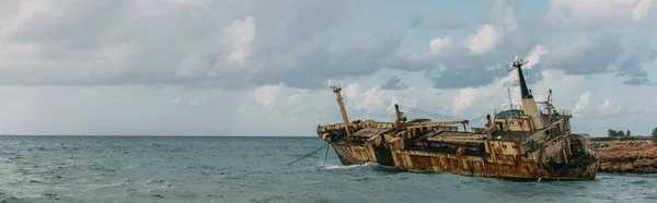 Panoramic shot of rusty ship in blue water of mediterranean sea — Stock Photo