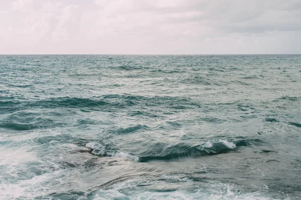 Blue water of mediterranean sea against sky with clouds — Stock Photo