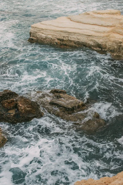 Weißer Schaum neben Felsen im blauen Wasser des Mittelmeeres — Stockfoto