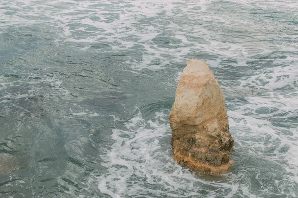 Espuma blanca cerca de piedra mojada en agua de mar mediterráneo en cyprus - foto de stock