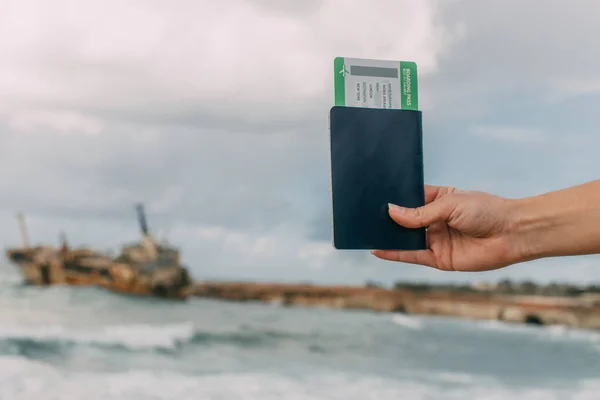 Cropped view of traveler holding passport and boarding pass near mediterranean sea — Stock Photo