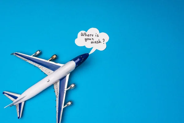 Vista superior del avión de juguete y la burbuja del habla con dónde está la inscripción de la máscara en la superficie azul - foto de stock