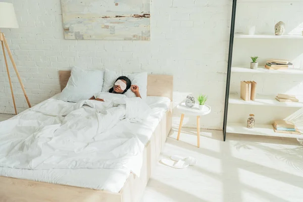 Junge afrikanisch-amerikanische Frau schläft in geräumigem Schlafzimmer — Stockfoto