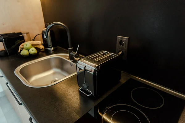 Плита, раковина и тостер с фруктами на столе на кухне — стоковое фото