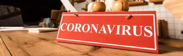 Cultivo horizontal de tarjeta roja con letras de coronavirus en la mesa en la cafetería - foto de stock