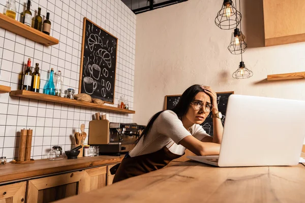 Schockierter Café-Besitzer blickt auf Laptop auf Tisch im Café — Stock Photo