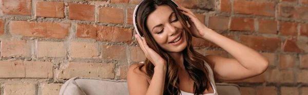 Attractive smiling girl listening music with headphones during self isolation, website header — Stock Photo
