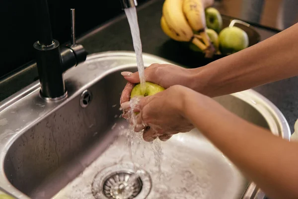 Abgeschnittene Ansicht eines Mädchens, das während der Quarantäne Früchte im Waschbecken wäscht — Stockfoto