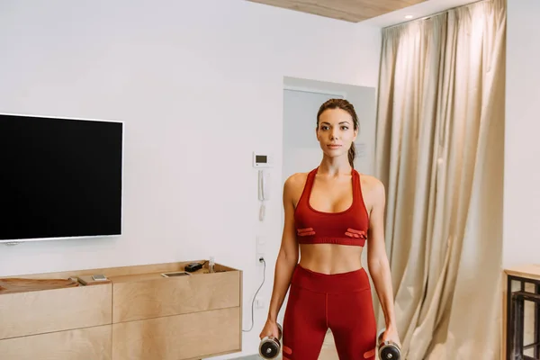 Beautiful girl training with dumbbells at home during self isolation — Stock Photo