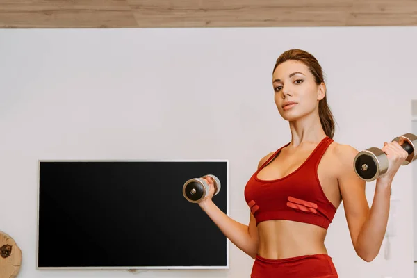 Attractive woman training with dumbbells at home during self isolation — Stock Photo