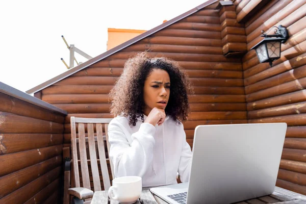 Displeased african american freelancer using laptop outside — Stock Photo