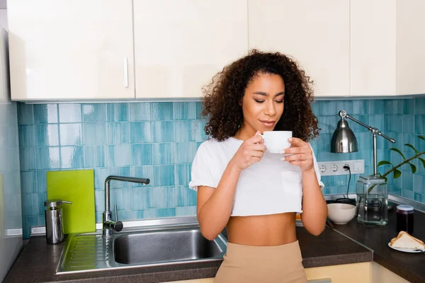 Rizado africano americano chica mirando taza de café - foto de stock