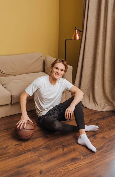 Felice uomo in possesso di basket mentre seduto sul pavimento, fine del concetto di quarantena — Foto stock