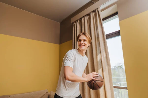 Hombre sonriente sosteniendo baloncesto en casa, fin del concepto de cuarentena - foto de stock