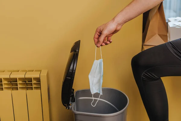 Cropped view of man throwing medical mask in trash can, end of quarantine concept — Stock Photo