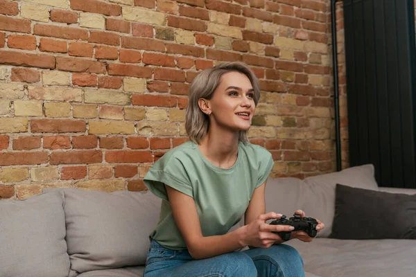 KIEW, UKRAINE - 30. April 2020: Aufgeregtes Mädchen spielt zu Hause Videospiel mit Joystick — Stockfoto