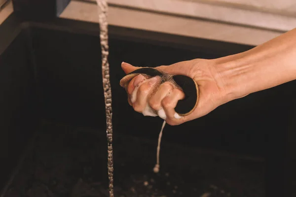 Vista ritagliata della mano femminile con spugna bagnata e sapone — Foto stock