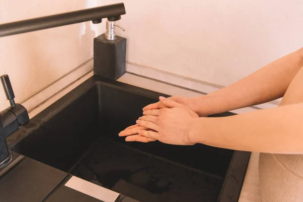 Vista recortada de la mujer lavándose las manos en el baño - foto de stock