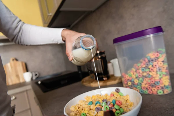 Обрізаний вид на людину, що ллє молоко в миску з пластівцями під час приготування сніданку — стокове фото