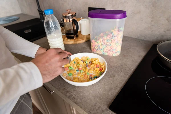 Cropped view of man mixing flakes with milk for breakfast — Stock Photo