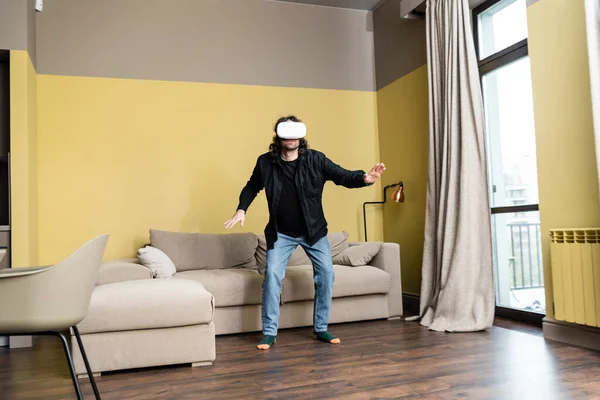 Man in virtual reality headset standing in living room — Stock Photo
