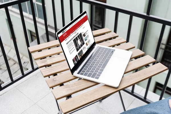 KIEW, UKRAINE - 25. April 2020: Ausgeschnittene Ansicht eines Mannes, der in der Nähe eines Laptops sitzt, mit bbc-News-Website auf dem Balkon — Stockfoto