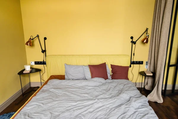 Paquete con comida para llevar y libro en la mesita de noche en el dormitorio - foto de stock