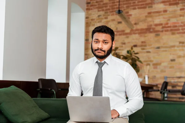 Chateado Africano americano freelancer em terno usando laptop na sala de estar — Fotografia de Stock