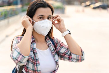 Çevre kirliliğini ve virüsü korumak için N95 maskesi takan Asyalı kadın. Covid-19 Coronavirus ve Hava kirliliği pm2.5 kavramı.